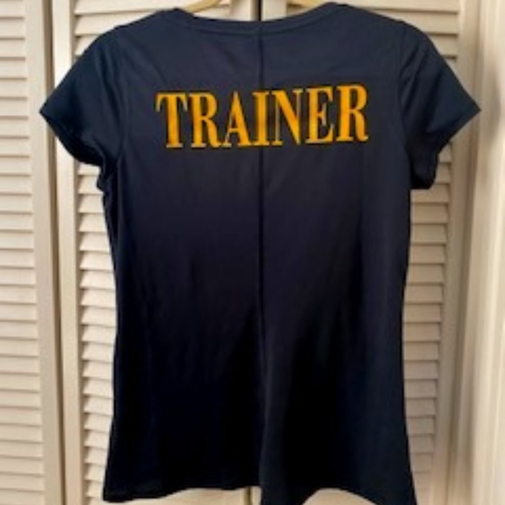 Size Medium Under Armour black shirt - Gold's Gym logo front; "Trainer" on back